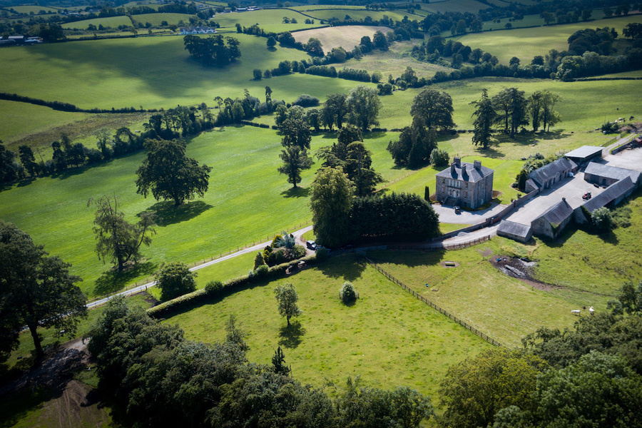 The 117-acre property mixes prime agricultural land with mature woodland and farmyard.